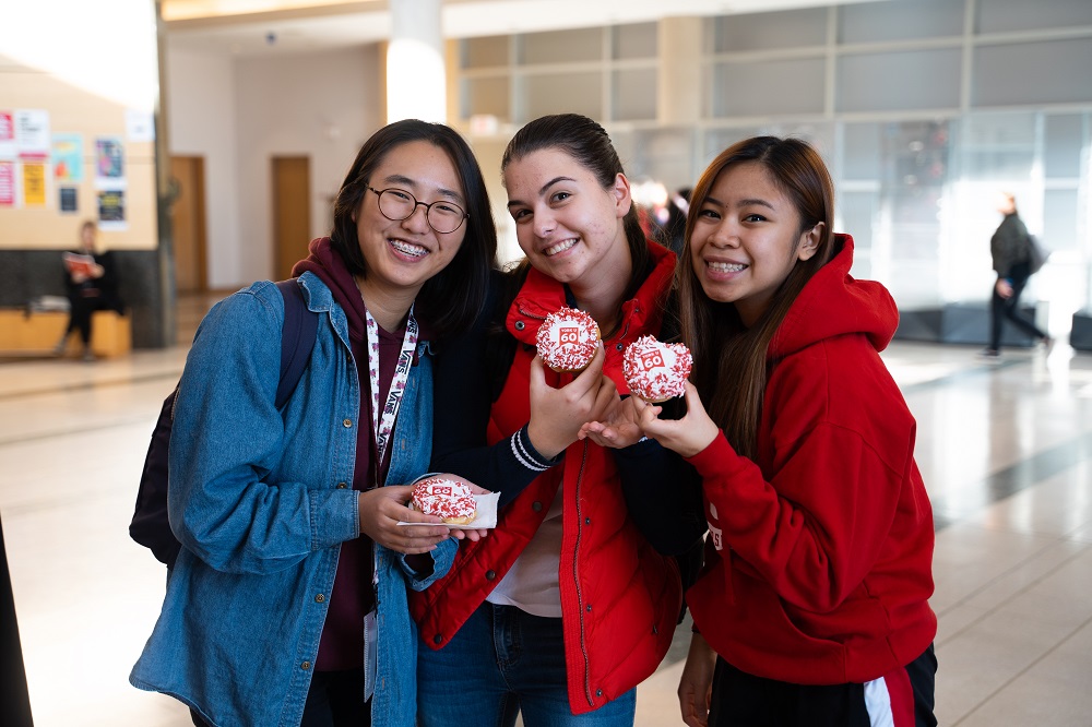 Three students with York U merch in their hand